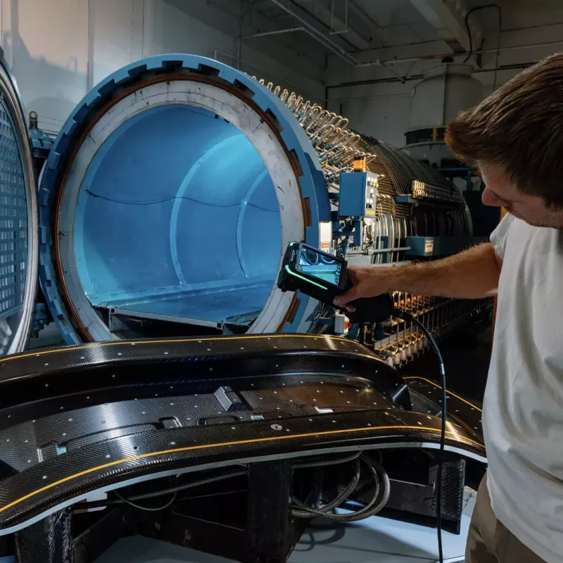 Użytkownik HandySCAN EVO skanujący komponent z&nbsp;włókna węglowego